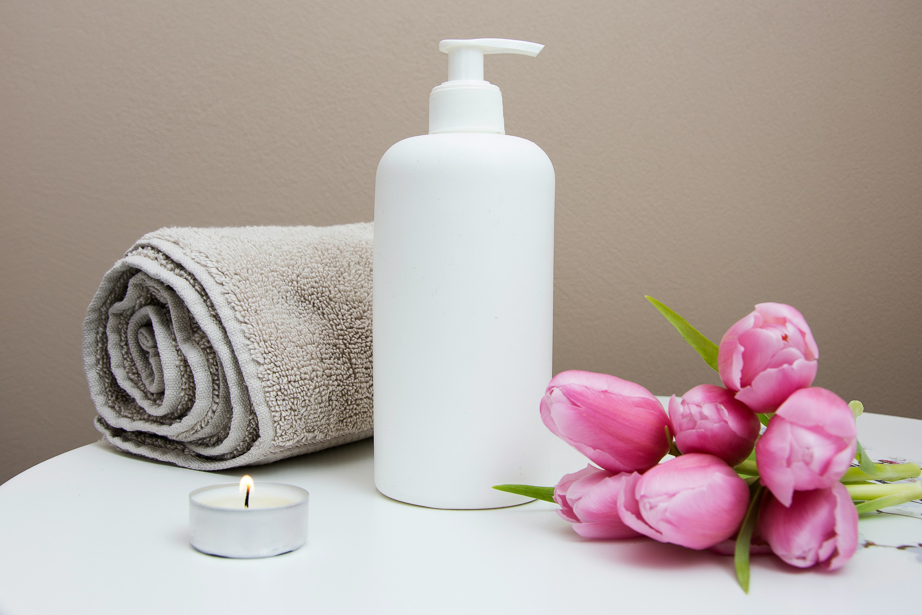 MedSpa treatment room setup with skincare products, folded towel, candle, and fresh flowers representing the boutique independent clinic experience that AI search can highlight when structured data is in place